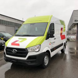 lieferwagen mit gru  nen akzenten foliert und grosse logos im digitaldruck verfahren erga  nzt